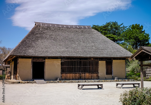 Photos Japan historic thatched roof house , traditional roof architecture in brown color against the blue clouds sky, traditional Japanese cottage roof in hitachi, Japan