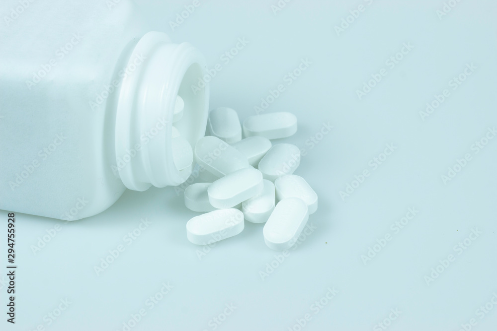 Opioid epidemic, painkillers and drug abuse concept with close up on a bottle of prescription drugs and hydrocodone pills falling out of it on white Opioid epidemic, painkillers and drug abuse concept with close up on a bottle of prescription drugs and hydrocodone pills falling out of it on white