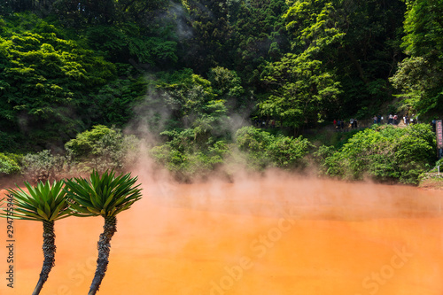 Chinoike Jigoku ,Blood pond hell , orange or Red Blood Hell Pond green trees  surrounding onsen, Beppu, Oita-shi, japan. photo