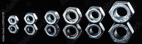 panoramic shot of shiny new metallic nuts isolated on black © LIGHTFIELD STUDIOS