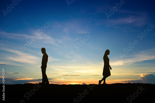Silhouettes of couple man and woman broken heart at nature sunset. Love concept.