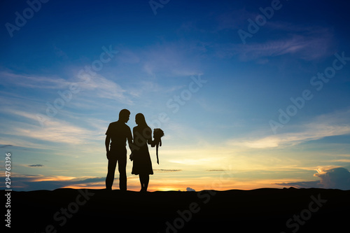 Silhouettes of couple man and woman in nature sunset background. Love concept. © cofficevit