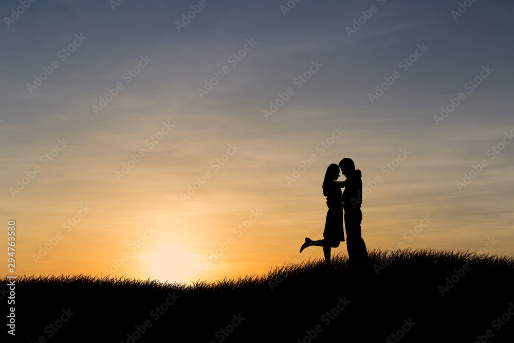 Silhouettes of couple man and woman in nature sunset background. Love concept.