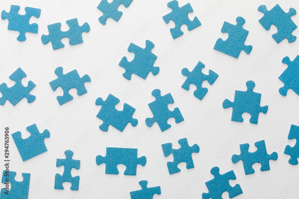 top view of scattered blue jigsaw puzzle on white background top view of scattered blue jigsaw puzzle on white background