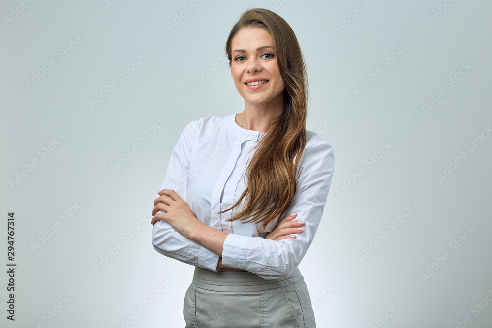 Smiling woman in white shirt posing with crossed arms. Smiling woman in white shirt posing with crossed arms.
