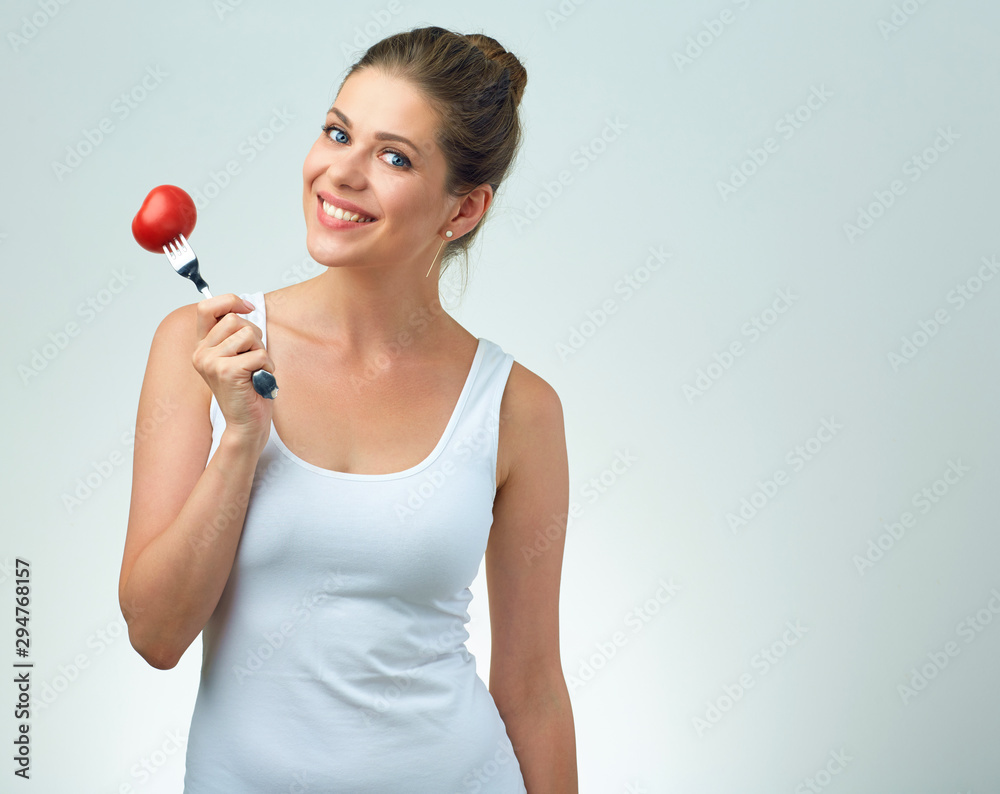 Smiling woman holding tomato on fork. Smiling woman holding tomato on fork.