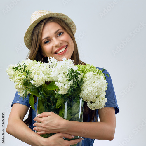 Young woman holding big glass vase with white flowers. © Yuriy Shevtsov