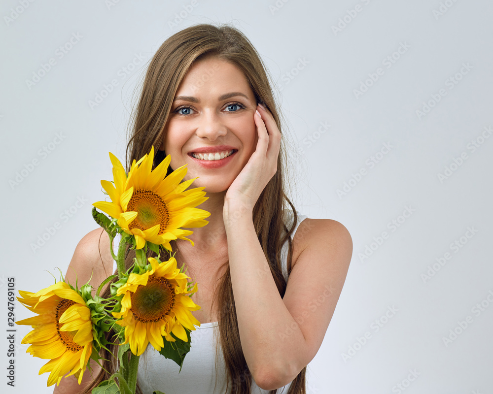 Happy woman with toothy smile holding sunflowers bouquet.