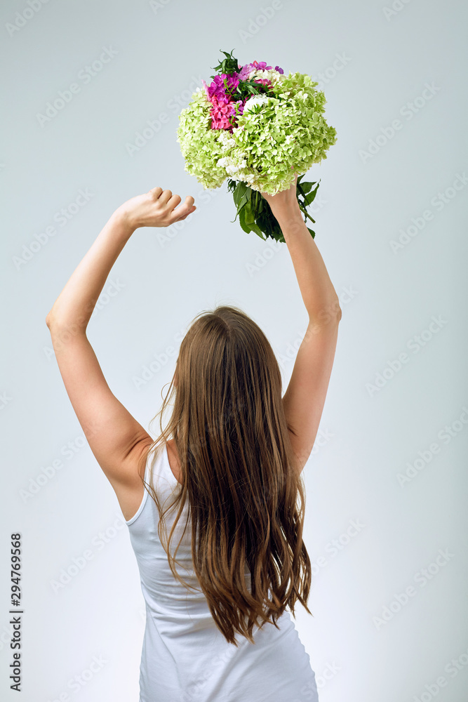 Woman holding flowers overhead, raised hands up. Woman holding flowers overhead, raised hands up.