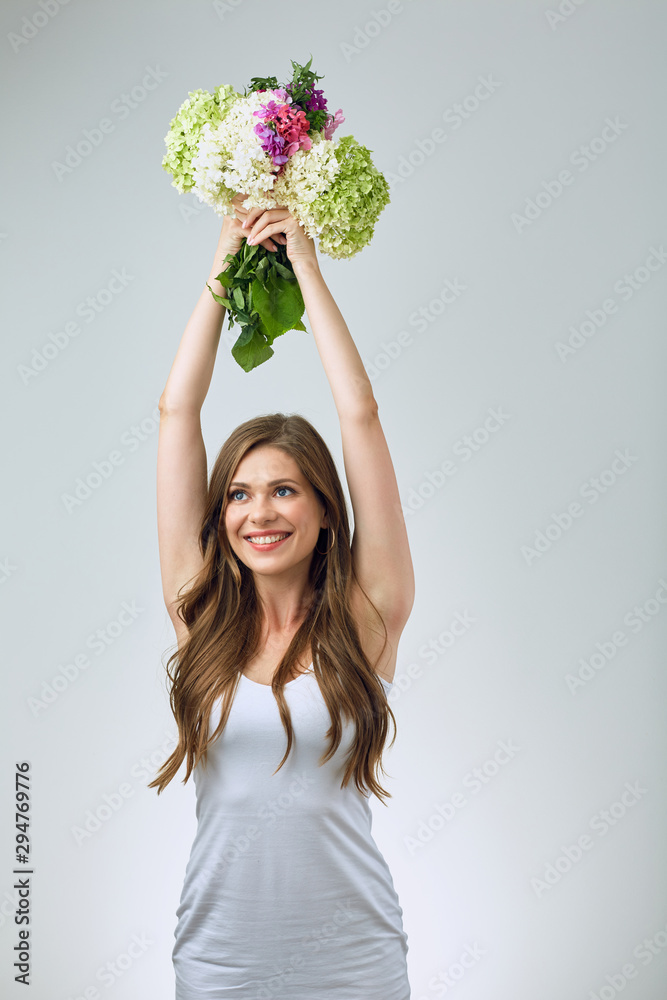 Happy bride girl in white dress holding flowers over head. Happy bride girl in white dress holding flowers over head.
