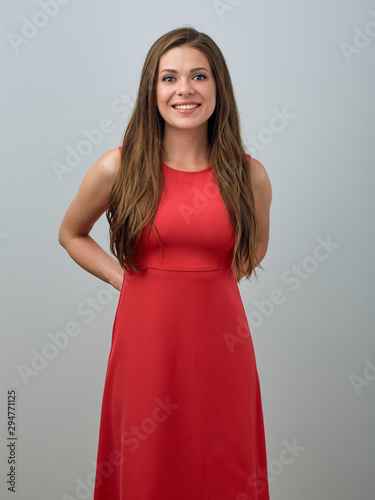 Smiling woman in red dress holding hands back.