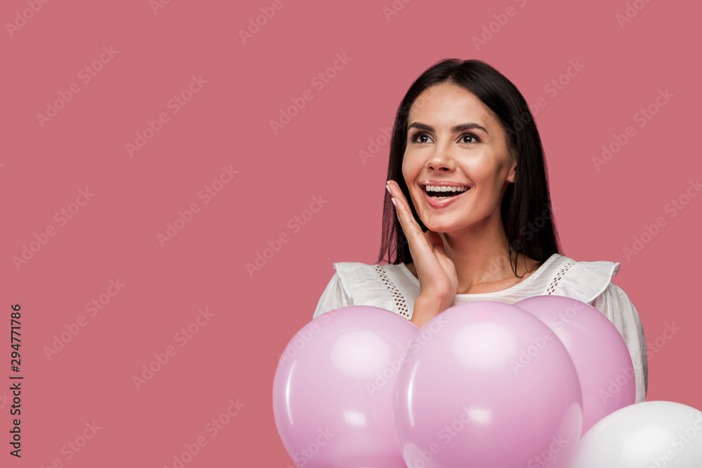 cheerful girl in dress holding balloons and touching face isolated on pink cheerful girl in dress holding balloons and touching face isolated on pink