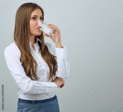 Young woman in white shirt drinking water.