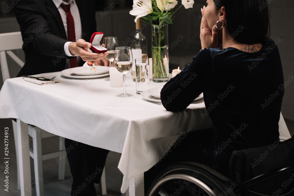 cropped view of young man making wedding proposal to disabled girlfriend while having romantic dinner cropped view of young man making wedding proposal to disabled girlfriend while having romantic dinner