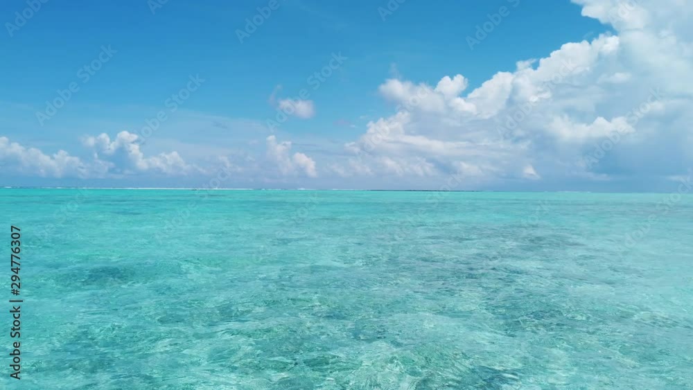 Seamless Loop video: Beautiful ocean seascape against sky. Turquoise sea waves in crystal clear water in reef lagoon. Stunning blue ocean during sunny day.