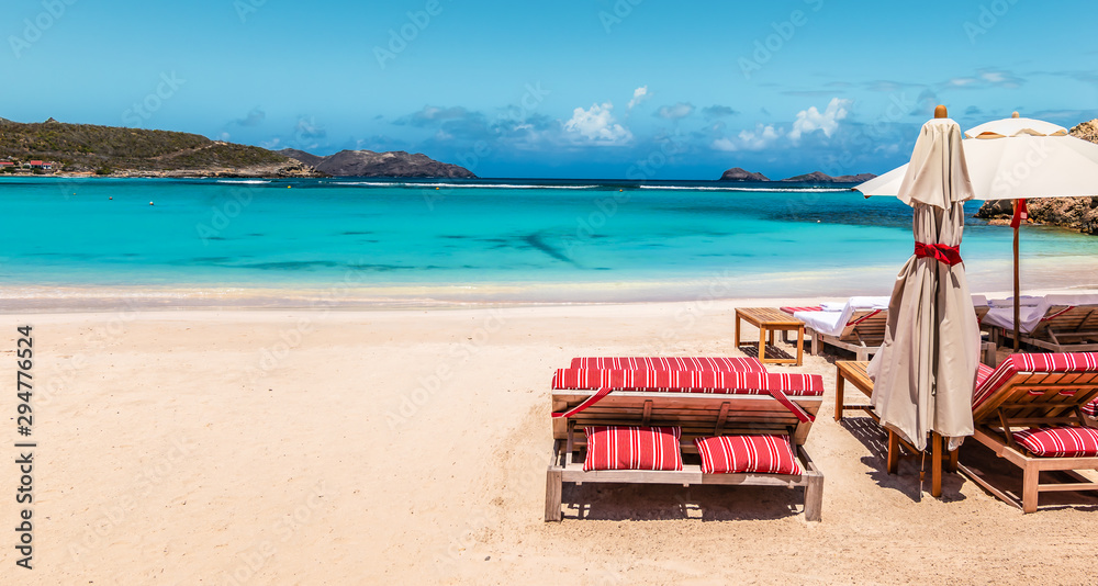 Tropical summer vacation background with  white sand beach and lounge chairs. Luxury holidays and vacation concept for tourism.