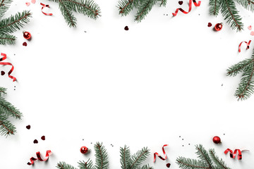 Creative frame made of Christmas fir branches on white background with red decoration, pine cones. Xmas and New Year greeting card, winter holiday. Flat lay, top view