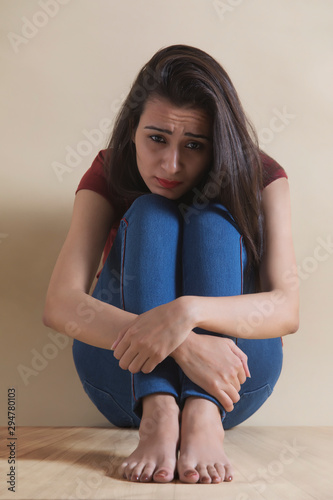 Young girl sitting alone in distress	