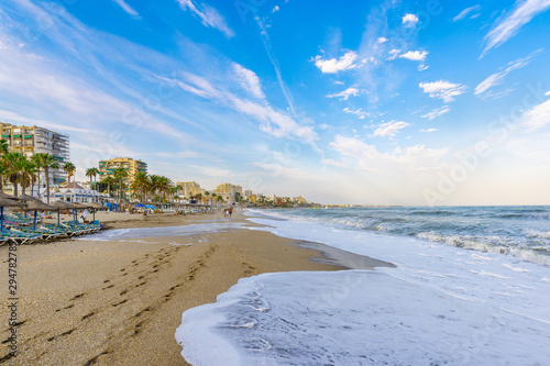 The city beach. A turbulent sea washes footprints in the sand. Benalmadena, Malaga, Andalusia, Spain, photo