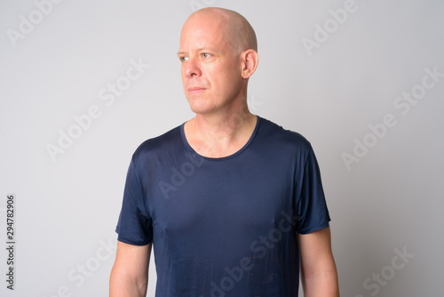 Portrait of mature handsome bald man thinking and looking away
