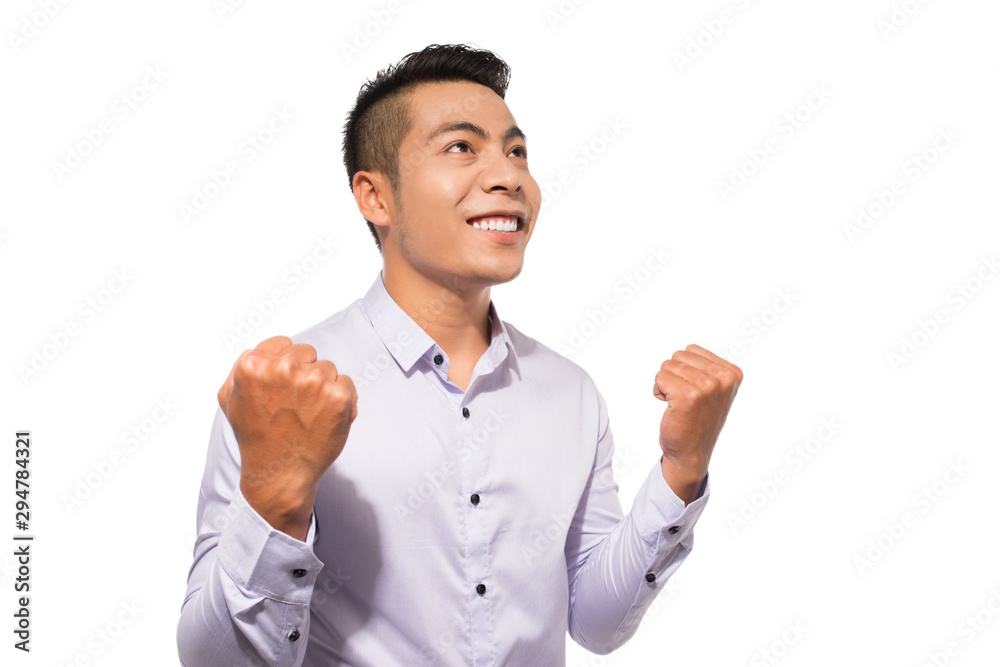 Portrait of an asian excited casual man standing with raised hands Portrait of an asian excited casual man standing with raised hands