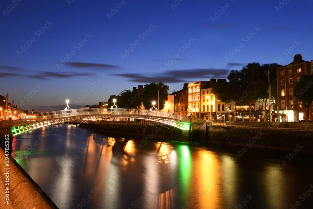 Dublin, Ireland. Night view of famous illuminated Ha Penny Bridge in Dublin, Ireland, at sunset