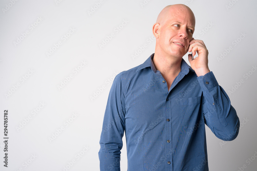 Portrait of happy mature bald businessman talking on the phone