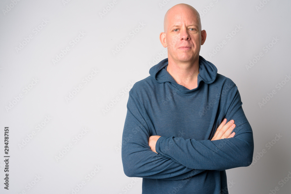 Portrait of mature handsome bald man with arms crossed