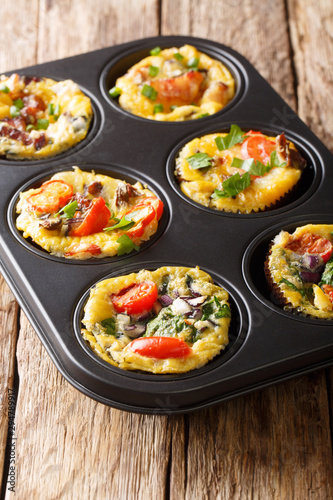 egg muffins omelet with bacon, tomatoes, spinach and mushrooms close-up in a baking dish. vertical