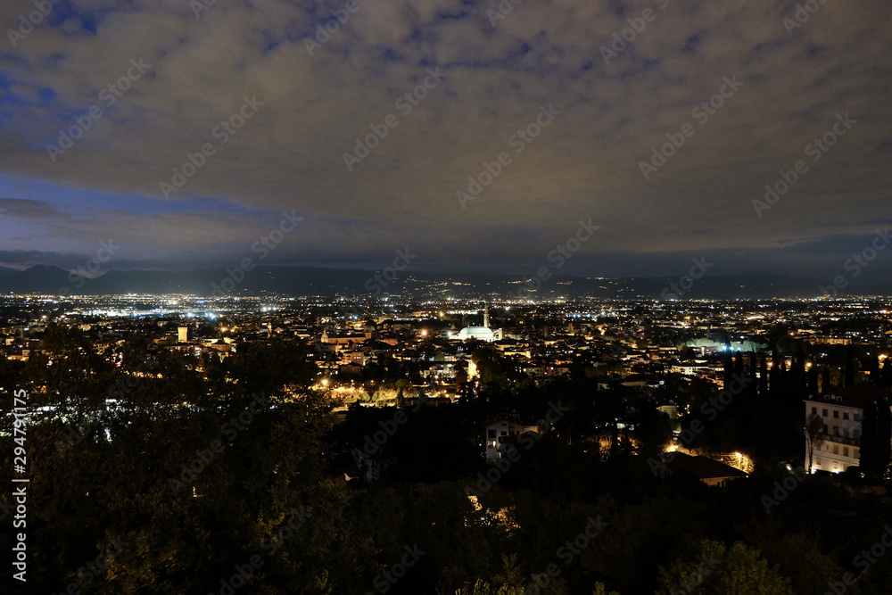 wide night panorama of the city of Vicenza and the famous monument called Basilica Palladiana with the tall Clock Tower. Vicenza, Veneto, Italy - October 3th, 2019