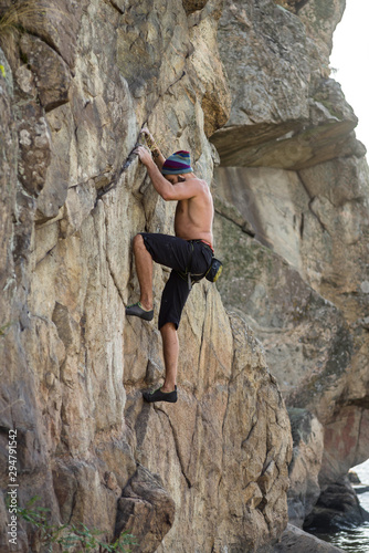 Man cliff climber is climbing a rock.