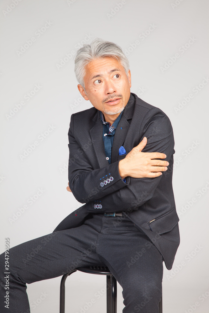 Hombre de mediana edad, de origen japonés, sentado en una silla, reflexionando, pensando, preocupado Hombre de mediana edad, de origen japonés, sentado en una silla, reflexionando, pensando, preocupado