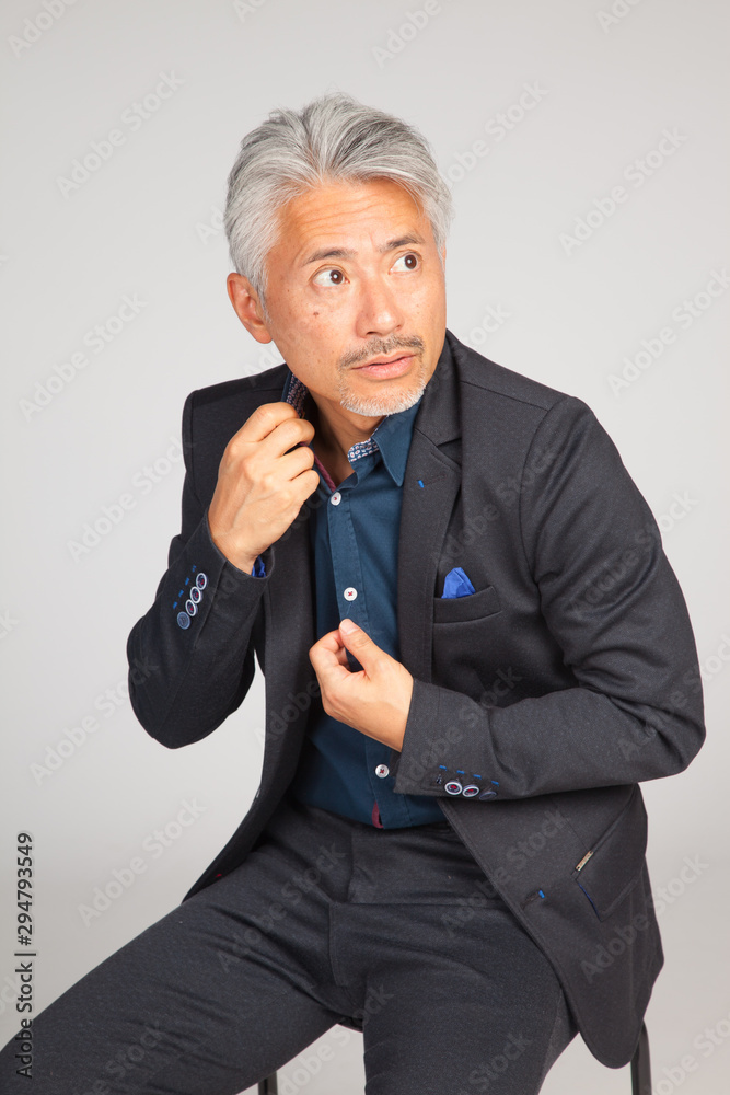 Hombre de mediana edad, de origen japonés, sentado en una silla, reflexionando, pensando, preocupado Hombre de mediana edad, de origen japonés, sentado en una silla, reflexionando, pensando, preocupado