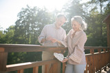 Mature adults smiling while leaving little heart on the bridge