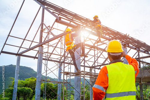 Engineer worker in protective helmet working at the house building ,Construction worker control in the construction of roof structures on construction site. photo