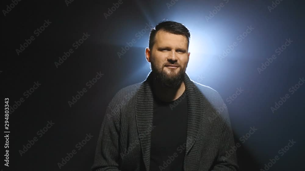 Studio portrait of a handsome bearded caucasian man showing much money and kissing it on black background with backlight and halo around his head. Concept of intellectual work and earning with brain Studio portrait of a handsome bearded caucasian man showing much money and kissing it on black background with backlight and halo around his head. Concept of intellectual work and earning with brain