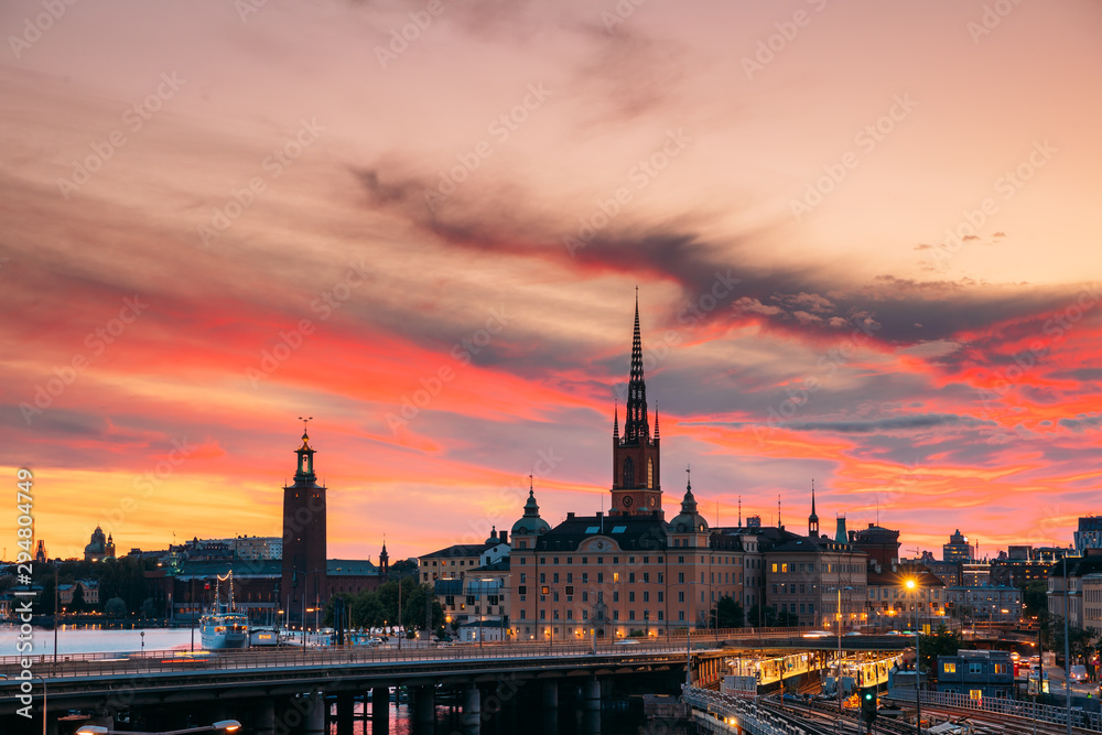 Fototapeta Stockholm, Sweden. Scenic View Of Stockholm Skyline At Summer Evening. Famous Popular Destination Scenic Place Under Dramatic Sky In Sunset Lights. Riddarholm Church, Subway Railway