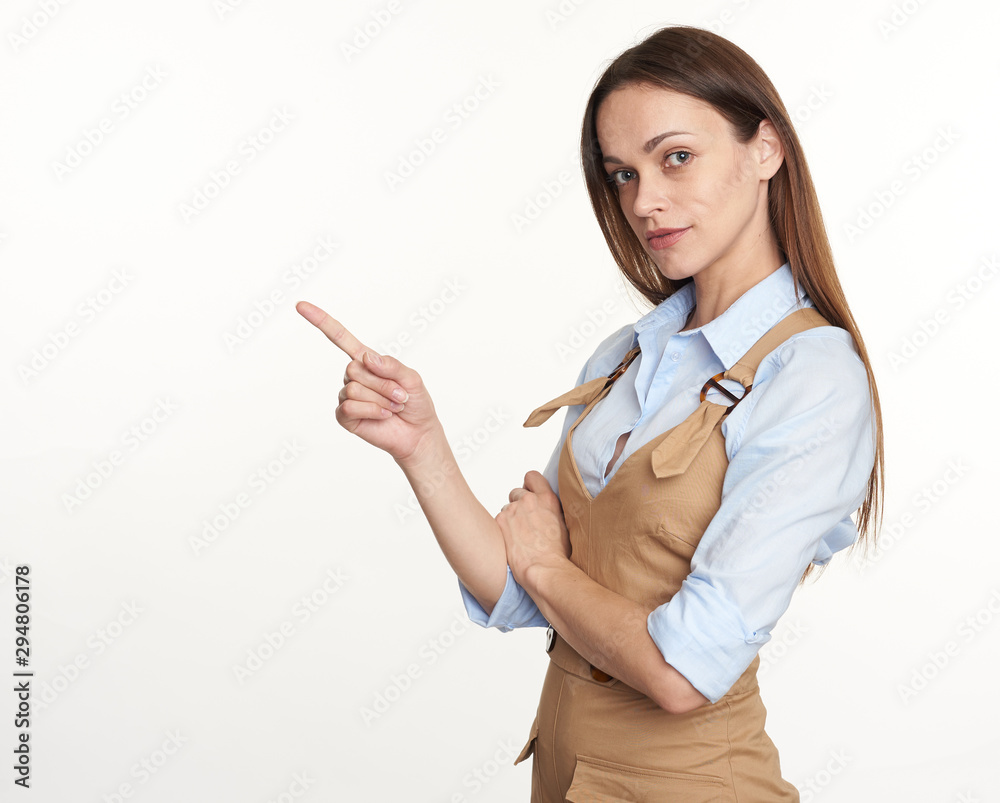 Pretty brunette woman is pointing finger to copy space