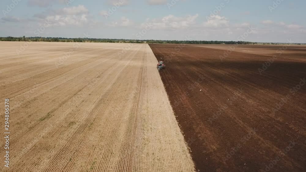 flight over a tractor that plows the land