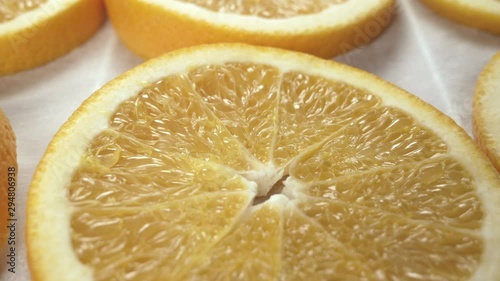 Fresh orange slices on baking paper. Close up. Slider side-to-side movement 
