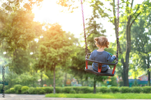 Wallpaper Mural Unrecognizable Little Caucasian girl riding swing at playground sunny summer day rear view Torontodigital.ca