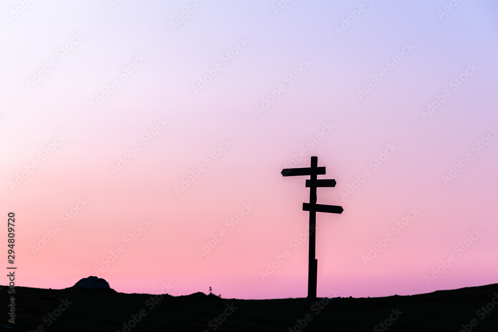 21/8-19, Mugarra, Pais vasco, Spain. A lonely  wooden signpost with three signs in different directions silhouetted against a beautiful sunset sky.