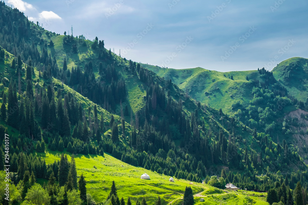 Beautiful view to the high green mountains and white kazakh national yurts, Almaty, Kazakhstan