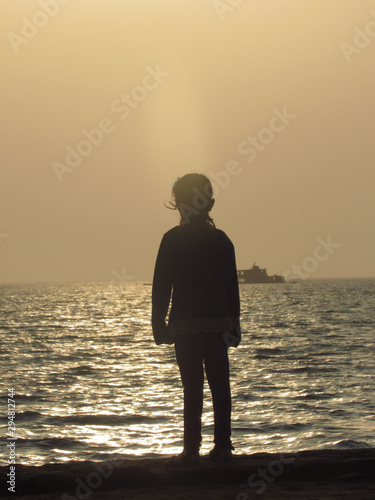 silhouette of girl on the beach at sunset