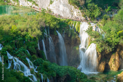 Tourists walking along the wooden boardwalk above the Large Waterfall at the Plitvice Lakes National Park in Croatia