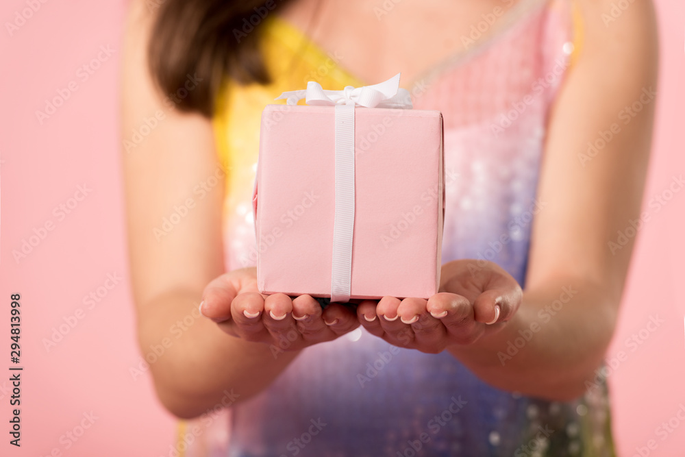 partial view of girl holding gift box isolated on pink partial view of girl holding gift box isolated on pink