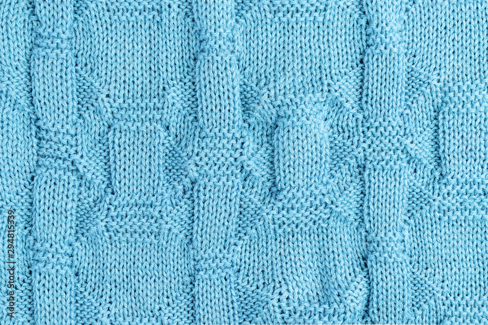 Fototapeta premium Knitted light blue background. Knit needles pattern.