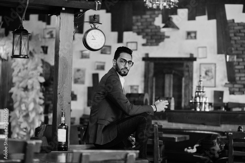 Valokuva Handsome well-dressed arabian man with glass of whiskey and cigar posed at pub