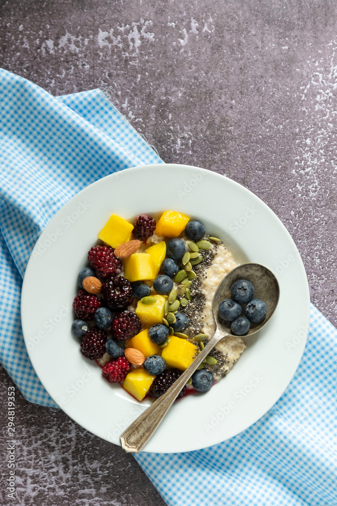 Healthy breakfast with oatmeal porridge, fruits and nuts. Blueberry, mango, pumpkin seeds, nuts, coffee cup. Top view. Clean eating, dieting, weight loss concept Healthy breakfast with oatmeal porridge, fruits and nuts. Blueberry, mango, pumpkin seeds, nuts, coffee cup. Top view. Clean eating, dieting, weight loss concept