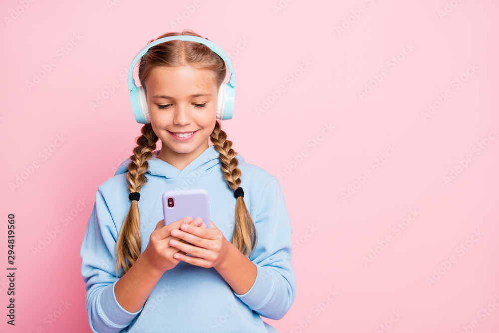 Photo of pretty little lady holding telephone hands turning on new popular youth song in earflaps wear casual blue hoodie pullover isolated pastel pink color background Photo of pretty little lady holding telephone hands turning on new popular youth song in earflaps wear casual blue hoodie pullover isolated pastel pink color background